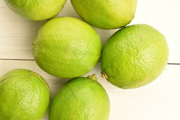 Several ripe lime on a painted wooden table.