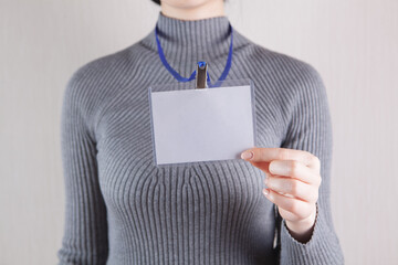 Young woman with blank badge on white background, closeup