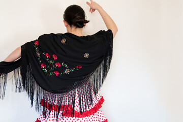 Hermosa mujer española con traje rojo de flamenca y mantón de manila negro bordado con flores. . Concepto de bailaora de sevillanas. Flamenco - obrazy, fototapety, plakaty