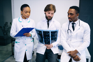 Medical center staff discussing the patient's X-ray. A group of doctors sitting at a medical conference