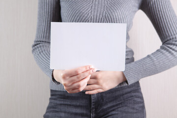 girl holding a blank sheet of paper in her hands