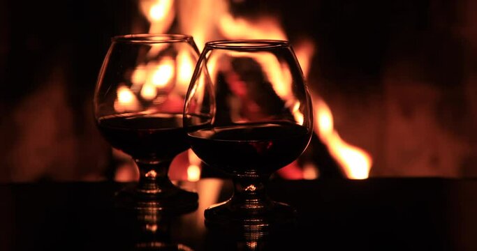 Two glasses of cognac and a bottle near the fireplace. Cozy evenings by the fireplace