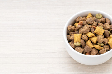 domestic pet dry food on wooden background. dried cat feed. above view