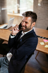 Businessman in conference room. Young businessman talking to the phone