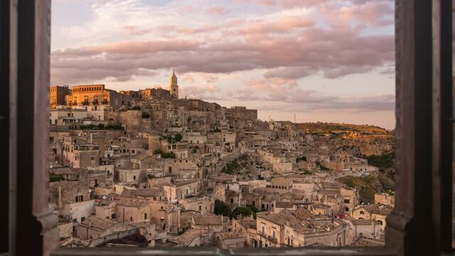 sassi di matera old town skyline timelapse from day to night seen from a window,time lapse of italian historic city at the sunset