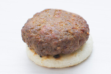 Seasoned meatloaf served with corn arepa on white wooden background