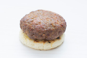 Seasoned meatloaf served with corn arepa on white wooden background
