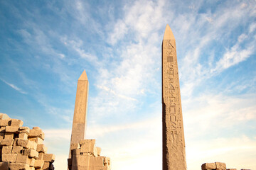  two pylons and a lot of ruin stones with cloudy blue sky , Luxor Karnak temple. Luxor, Egypt