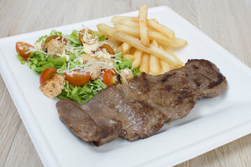 Homemade lunch with grilled meat and French fries