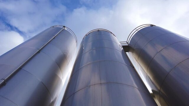 Large metal silo for storing raw material. Modern industrial plant.