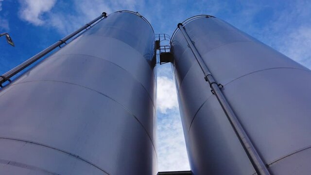 Large metal silo for storing raw material. Modern industrial plant.