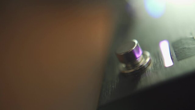 Pushing guitar pedal switch button with thumb