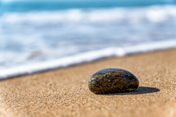 Ein Stein am Strand mit Meer im Hintergrund 