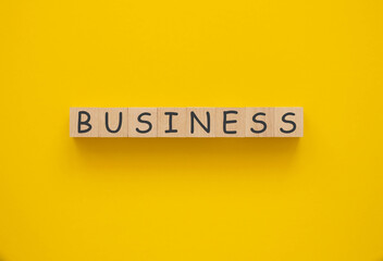 Business concept. Wooden cubes with business inscription. Yellow background