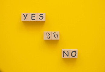 Words YES and NO on wooden blocks.