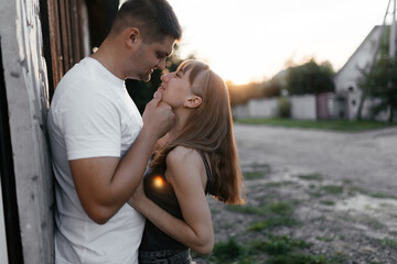 Fototapeta premium Husband going to kiss his wife. Man and woman kissing at the sunset. Happy couple on the street. 