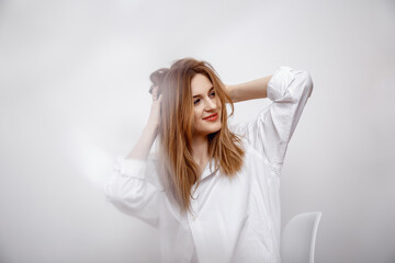 Naklejka premium Businesswoman confident portrait. Fashion shoot of young sexy in white studio street style. Fashion photo. Caucasian female with long hair. Close-up portrait of a beautiful girl of the European race.