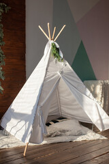 Kid's wigwam in children room. Interior in Scandinavian style. Play corner. 