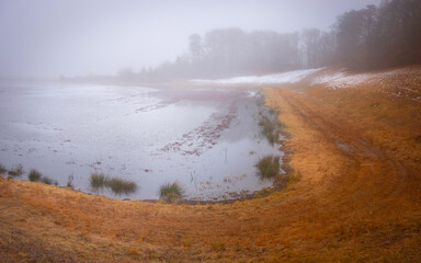 Curved Grassy Road at the Flooded Cranberry Bog in the Foggy Morning