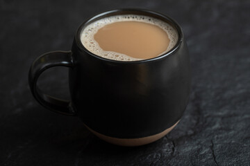 A black cup of coffee on a dark background