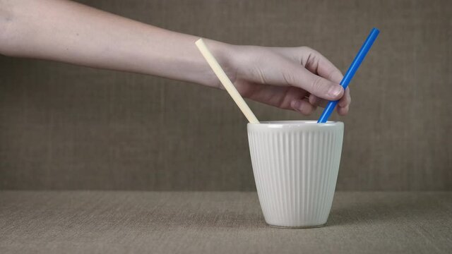 Life with eco friendly things. A wpman choose a paper straw in the glass with cocktail straws.