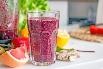 Wellness  smoothie of greens and wild berries in a transparent glass on the kitchen table