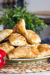 Samsa oriental Uzbek puff pastry pies with meat and pumpkin on a plate on the table, close-up. Triangular pies with sesame seeds, national authentic pastries