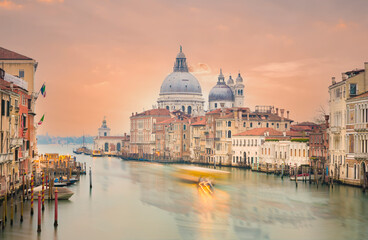 Fototapeta na wymiar Stunning view of the Venice skyline with the Grand Canal and Basilica Santa Maria Della Salute in the distance during a dramatic sunrise. Picture taken from Ponte Dell’ Accademia.