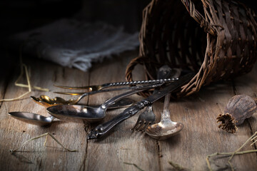 Old spoons and forks scattered on a rustic table
