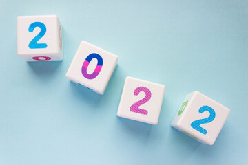 Cubes with colorful numbers 2022 located diagonally on a blue background. New year, calendar.