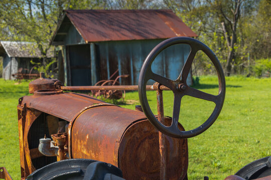 Old Rusty Tractor Close-up With Barn In Background