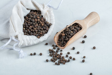 A white sack full of dried pepper on a gray background