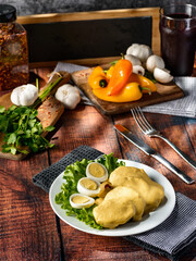 Traditional Peruvian food called Papa a la Huancaina made of cooked potatoes yellow pepper eggs on wooden table 