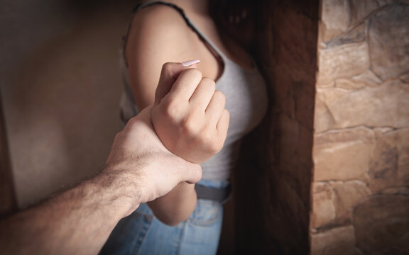 Angry male hand holding a woman hand. Abuse victim