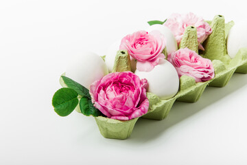 Easter composition of eggs and pink flowers. White background. Easter and Holidays concept. Minimalist style