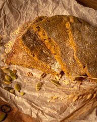 Made by hand fresh bread or tortillas and ear of ripe wheat on parchment paper on wooden table