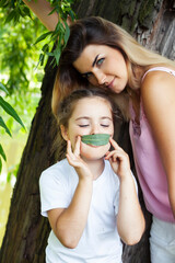 young pretty mother walking with little cute daughter outside in green park, lifestyle poeple concept