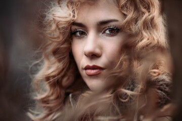 Fototapeta premium Close-up portrait of a young woman with blonde curly hair