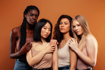 Fototapeta premium young pretty asian, caucasian, afro woman posing cheerful together on brown background, lifestyle diverse nationality people concept
