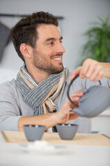 man pours tea from teapot