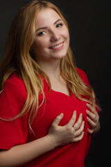 a blonde girl with an overweight plus size, a red overallposing on a dark Studio background