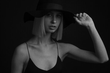 Black and white portrait blondes on black background in a hat and Tank Top With Thin Straps