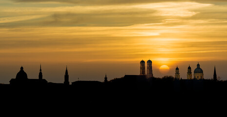 Silhouette Munich Skyline with dramatic orange sunset behind Frauenkirche