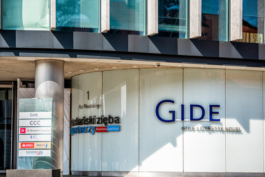 Warsaw, Poland - August 23, 2018: Downtown street road sign and sign for office building with Gide, CCC and Mitsubishi corportation