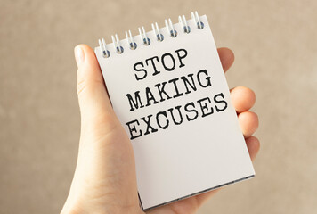 Closeup on businessman holding a card with text STOP MAKING EXCUSES, business concept image with...
