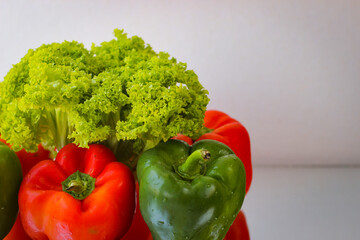 A few red and green bell peppers along with salad leaves