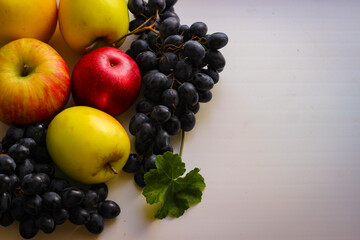 Fall fruits still life. Grapes and apples on a light background with room for copying