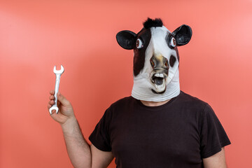 costumed person wearing a cow's head mask holding a mechanic's wrench