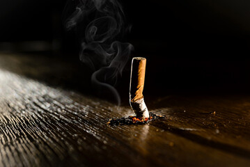 Smoking burning cigarette on a dark background. Stop smoking concept