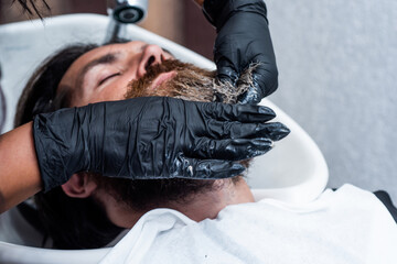 grooming. hair and beard styling. confident brutal guy with barbershop professional master. hipster washing in washbasin. male barber care. bearded man in hairdresser salon. beauty and fashion